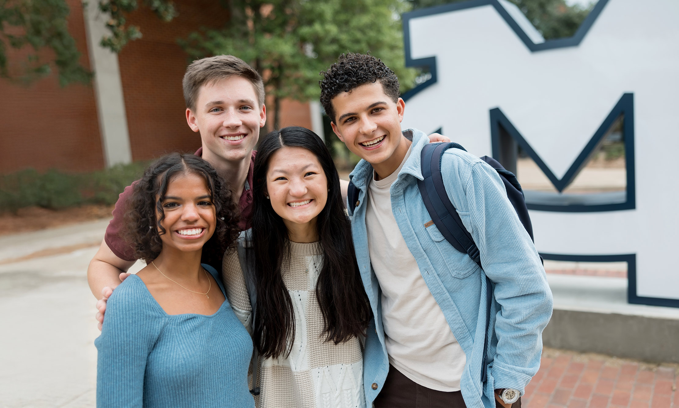 Students on Pedestrian street in front of the MC sign