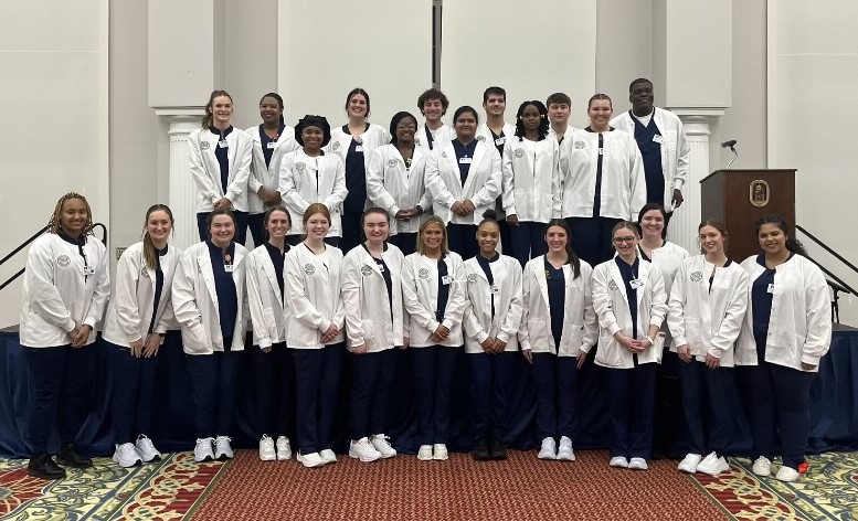 First-semester students proudly display the new coats they received during the School of Nursing's White Coat Ceremony Jan. 22. 