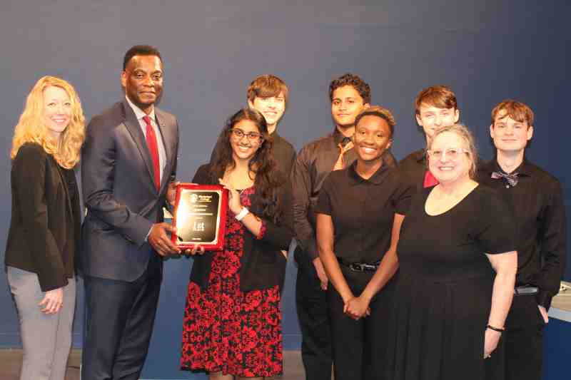 Dr. Keith Elder, provost and executive vice president at MC, presents the Mississippi Academic Competition championship plaque to members of the Clinton High School team after its defeat of Madison Ridgeland Academy in the tournament finale Feb. 22 in the Leland Speed Library. Cheli Vance, left, program coordinator in the Office of Continuing Education at MC, served as host of the tournament.