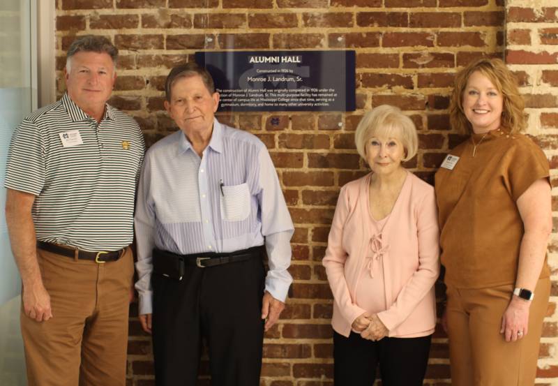 Jannelle Landrum Hamilton, second from right, and her husband, Dr. Joseph H. Hamilton Jr., second from left, pose with a plaque acknowledging Monroe J. Landrum Sr.'s contributions to the construction of Alumni Hall. The couple was treated to a tour of the building by Jim Turcotte, left, and Katrina Pace.