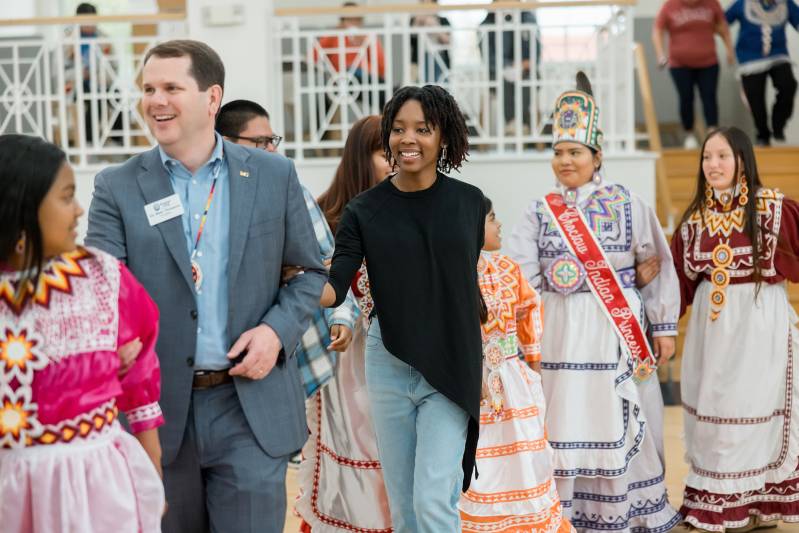 Mississippi College President Blake Thompson and Camryn Johnson, center, MC admissions counselor, join in a social dance with members of the Mississippi Band of Choctaw Indians during a previous Choctaw Expressions.