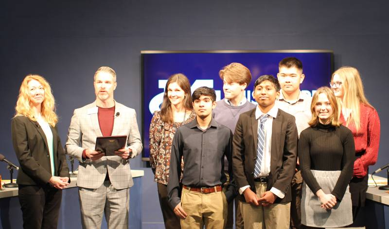 Cheli Vance, left, program coordinator in the Office of Continuing Education and academic competition emcee, and Jonathan Ambrose, second from left, associate vice president for the student experience and dean of students, present a plaque to members of the Jackson Academy team, winners of the 2022-23 Mississippi College Academic Competition.