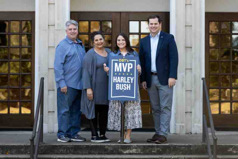 With her parents at her side, Harley Bush, second from right, administrative assistant and student coordinator in the Mississippi College School of Business, displays the MVP Award presented to her by Dr. Blake Thompson, right.