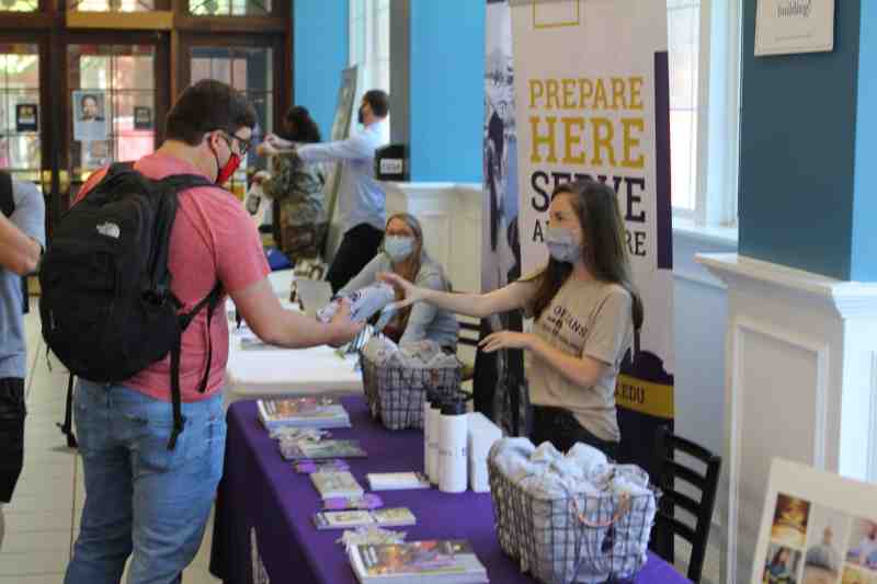 James Thornton, a fifth-year Christian studies major at MC and a New Orleans Baptist Theological Seminary recruit, receives information and a T-shirt from McKenzie Sizemore, an NOBTS representative, at Seminary Day in the cafeteria in the B. C. Rogers Student Center.