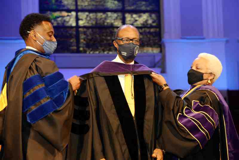 MC Law Dean Patricia Bennett and Provost Keith Elder hood Pastor Jerry Young, recipient of an honorary Doctor of Laws degree on May 14. Photo by Greg Campbell