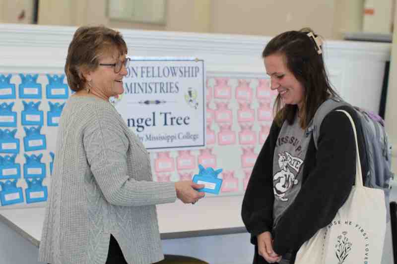 Shari Barnes, left, MC Community Services Center director, explains the Angel Tree giving program to Megan Collins, a sophomore Christian Studies student from Clinton.