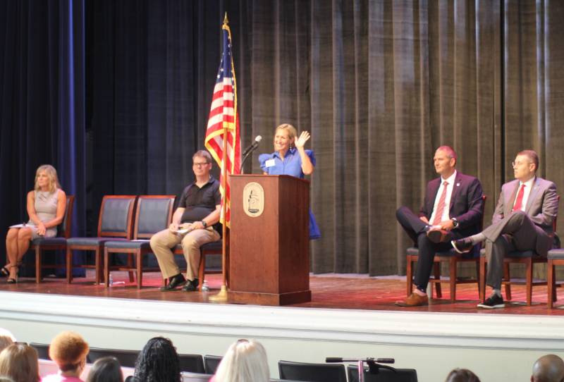 Cindy Melton, dean of the School of Education at Mississippi College, welcomes educators to the Clinton Public School District's Convocation. Joining her on stage are, from left, Paula DeYoung, Clinton Public School District trustee; Marshall Ramsey, noted political cartoonist and guest speaker; Andy Schoggin, superintendent of schools; and Mike Highfield, MC provost and executive vice president.